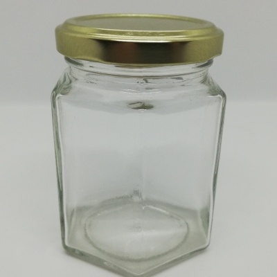 Frasco hexagonal de vidro transparente com tampa dourada