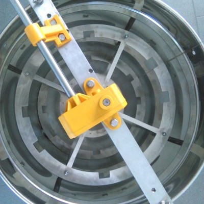 Centrífuga de colmeia metálica com partes amarelas e barra horizontal