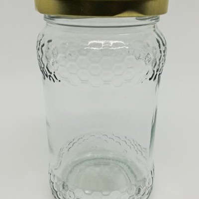 Frasco de vidro com padrão de favos de mel e tampa dourada