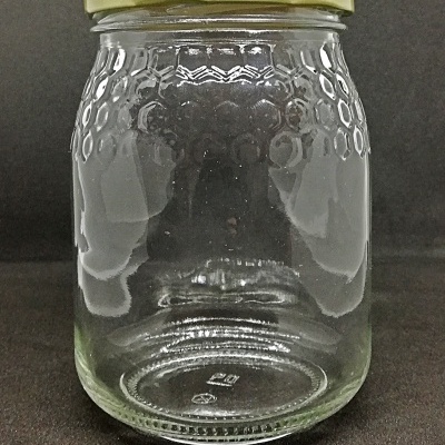 Frasco de vidro transparente com textura hexagonal e tampa dourada