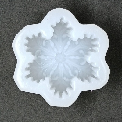 Molde branco em forma de floco de neve sobre fundo cinza escuro