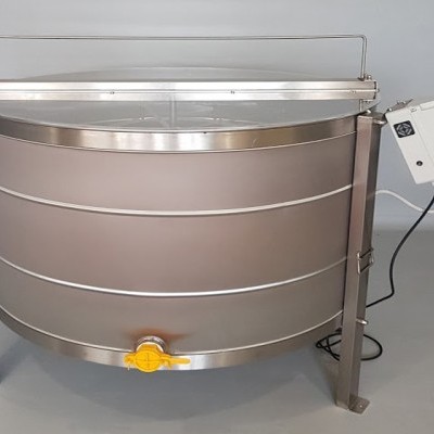 Tanque redondo industrial em aço inoxidável com torneira amarela e painel elétrico branco