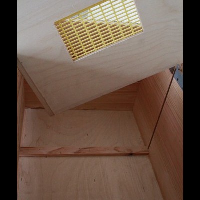 Caixa de madeira clara com tampa com grade amarela embutida