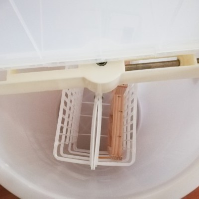 Interior de balde branco com suporte bege e cesto branco no centro