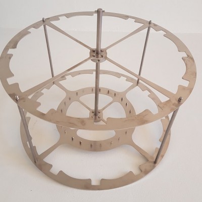 Estrutura metálica circular prateada com barras verticais e diagonais