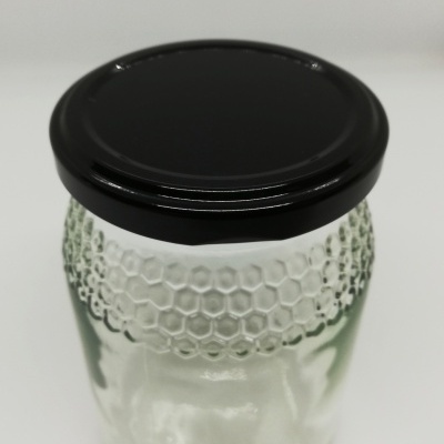 Frasco de vidro com tampa preta e textura em colmeia