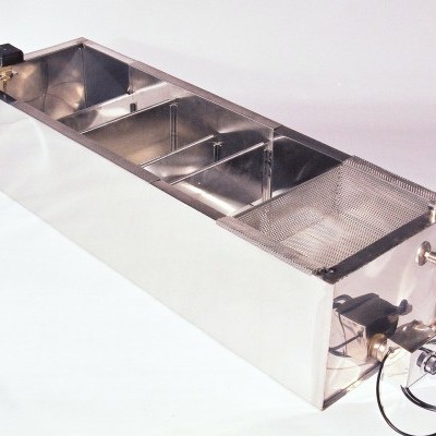 Aparelho metálico longo com divisórias internas e malha na extremidade