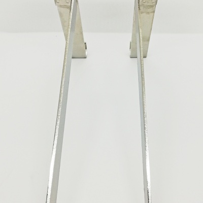 Dois cabides metálicos prateados com ganchos largos em superfície branca