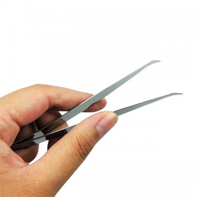 Mão segurando duas pinças de metal com pontas finas.