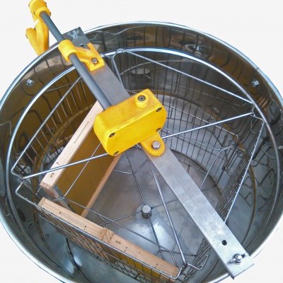 Aparelho de centrifugação de mel metálico com detalhes amarelos e cesta de arame