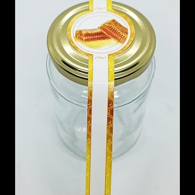 Frasco de vidro com tampa dourada e selo adesivo com imagem de bolachas