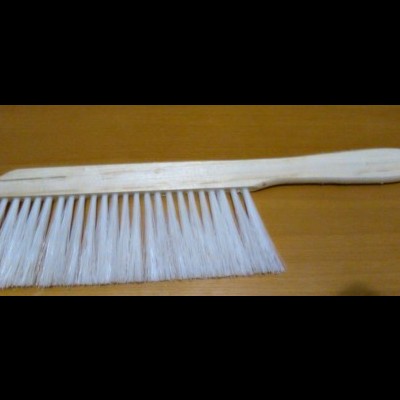 Pente de madeira com cerdas brancas sobre superfície de madeira