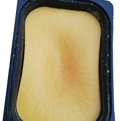 Barra de cera amarela dentro de caixa preta retangular