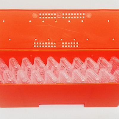 Caixa laranja com pequenas peças transparentes organizadas no interior