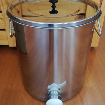 Recipiente de aço inox com tampa e torneira em chão de madeira