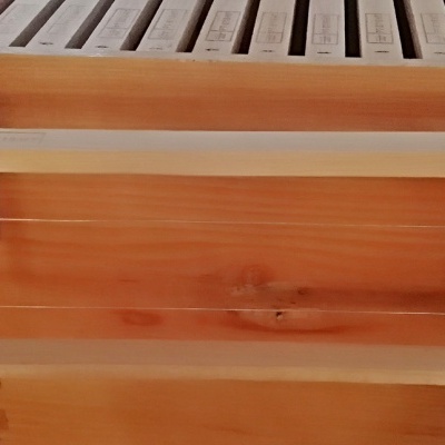 Estrutura retangular de madeira com aros de metal junto a móvel de madeira