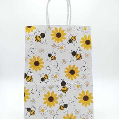 Saco de papel branco com padrão de abelhas e flores amarelas e brancas.