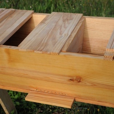 Colmeia de madeira natural para apicultura sobre relvado verde