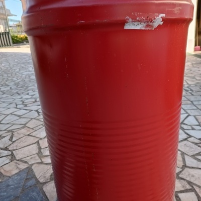 Tambor metálico vermelho com etiqueta parcialmente removida