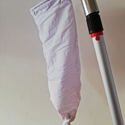 Suporte metálico com saco de tecido branco para lixo