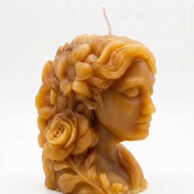 Vela esculpida em forma de busto feminino com flores e folhas