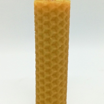 Vela cilíndrica amarela com padrão hexagonal tipo favo