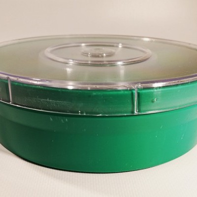 Embalagem redonda verde com tampa translúcida sobre superfície branca