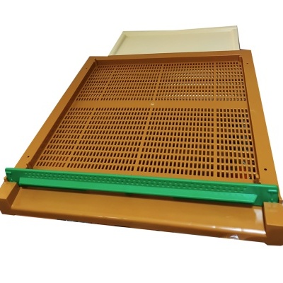 Grelha metálica castanha com barra verde sobre superfície branca