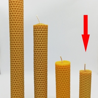 Quatro velas amarelas com padrão hexagonal em diferentes alturas sobre fundo branco