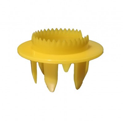 Peça plástica amarela com dentes e quatro pernas sobre fundo branco