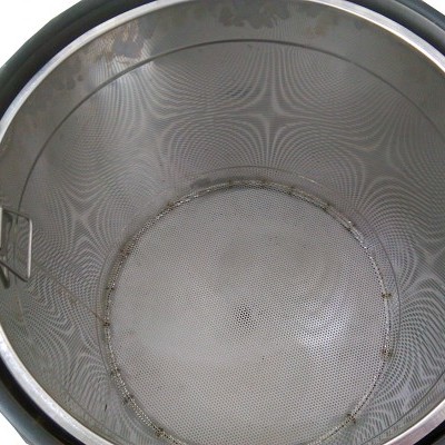 Peneira metálica redonda com alças dentro de recipiente preto