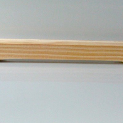 Régua em madeira clara com textura natural em superfície branca vista de lado