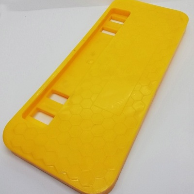 Base de plástico amarela com padrão hexagonal e recortes retangulares