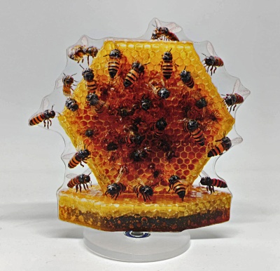 Objeto decorativo em forma de favo de mel com abelhas em acrílico.