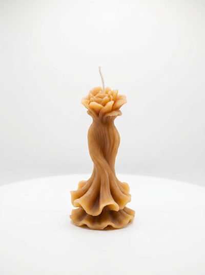 Vela decorativa em forma de rosa castanho claro sobre superfície branca
