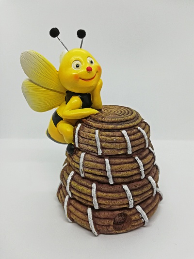 Estatueta decorativa de abelha amarela e preta numa colmeia.