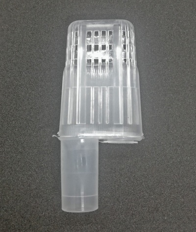 Peça plástica transparente com texturas e grades sobre fundo escuro