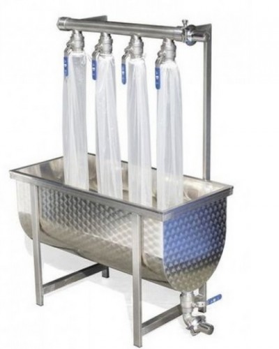 Tanque metálico com quatro torneiras e mangas plásticas transparentes penduradas