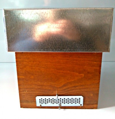 Caixa de madeira com tampa metálica e placa perfurada frontal