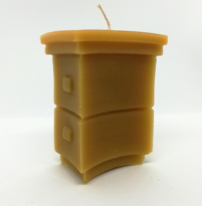 Vela castanha em forma de móvel de quarto com puxador, fundo branco