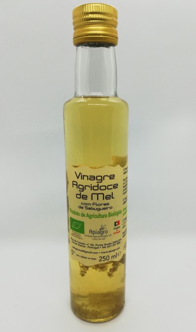 Garrafa de vinagre agridoce de mel com tampa amarela sobre fundo branco