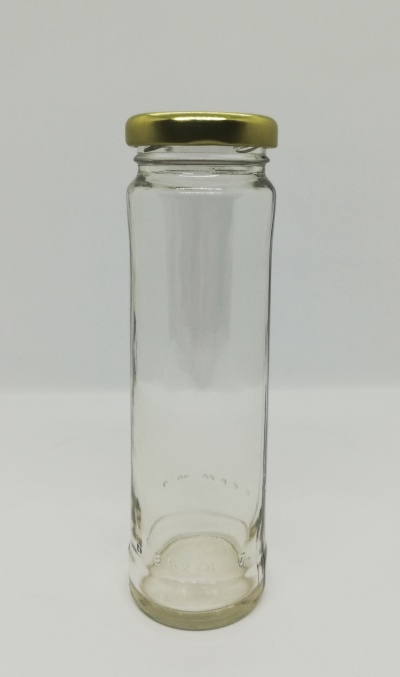 Frasco de vidro com tampa dourada sobre fundo cinza