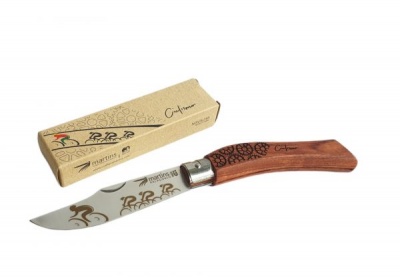 Faca com cabo de madeira e lâmina metálica decorada ao lado de caixa de papelão