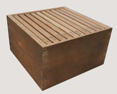 Caixa de madeira castanha com tampa de barras paralelas de madeira clara