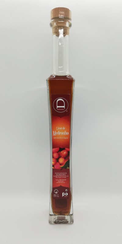 Garrafa de licor de medronho com tampa de cortiça e etiqueta vermelha com medronhos.