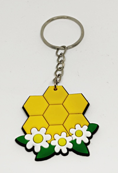 Porta-chaves amarelo em forma de favos de mel com flores brancas e folhas verdes