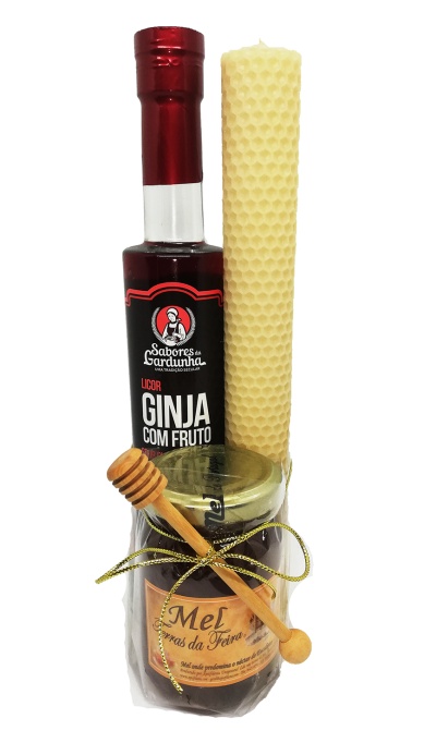 Conjunto com garrafa de licor ginja, vela de cera e frasco de mel com colher de mel.