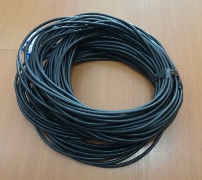 Cabo preto enrolado sobre superfície de madeira