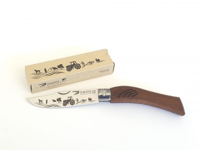 Faca com cabo de madeira e lâmina gravada ao lado de caixa de cartão com desenhos e texto Martins RS