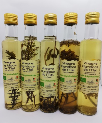Garrafas de vinagre agridoce de mel com ervas, rótulo em português e tampa dourada.